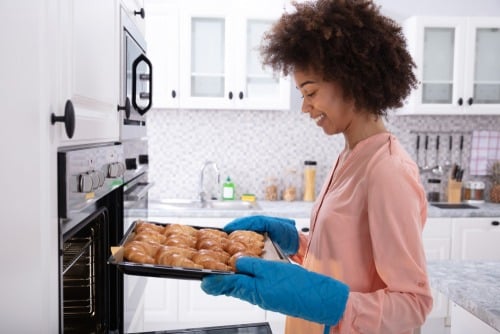 Woman baking food in oven