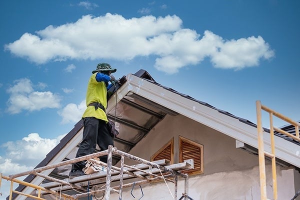 Man working on roof of house