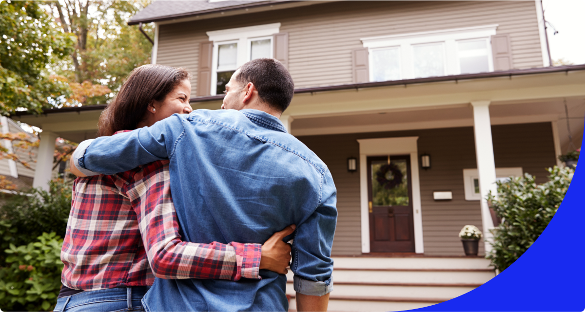 Couple hugging outside of house