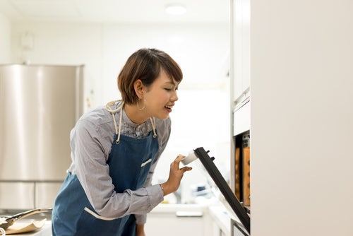 woman looking in oven