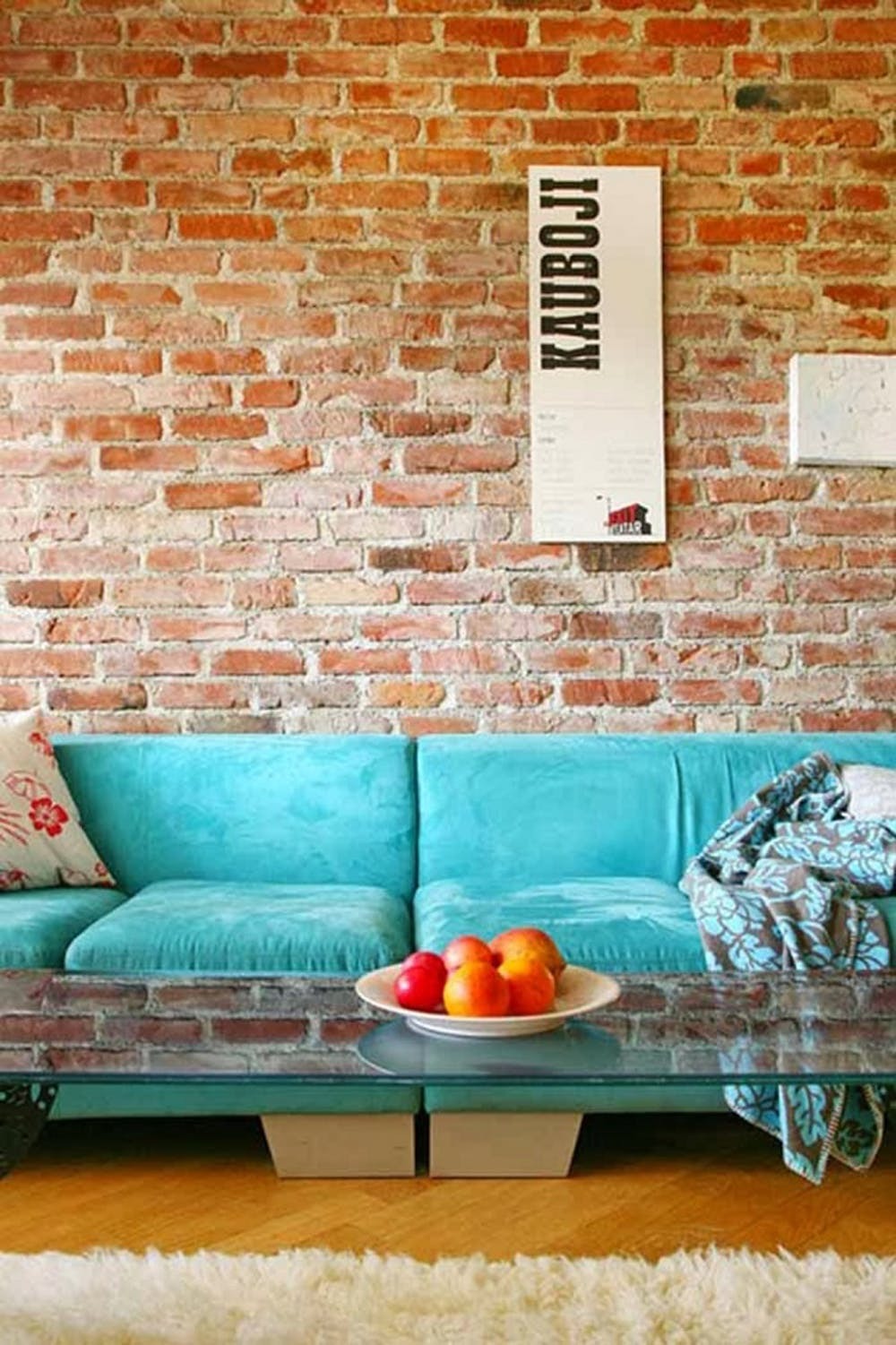 colored couch in front of brick wall