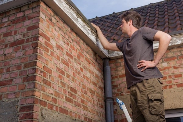 man inspecting roof