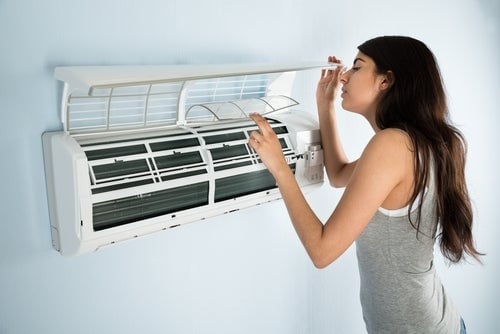 woman looking inside ac wall unit